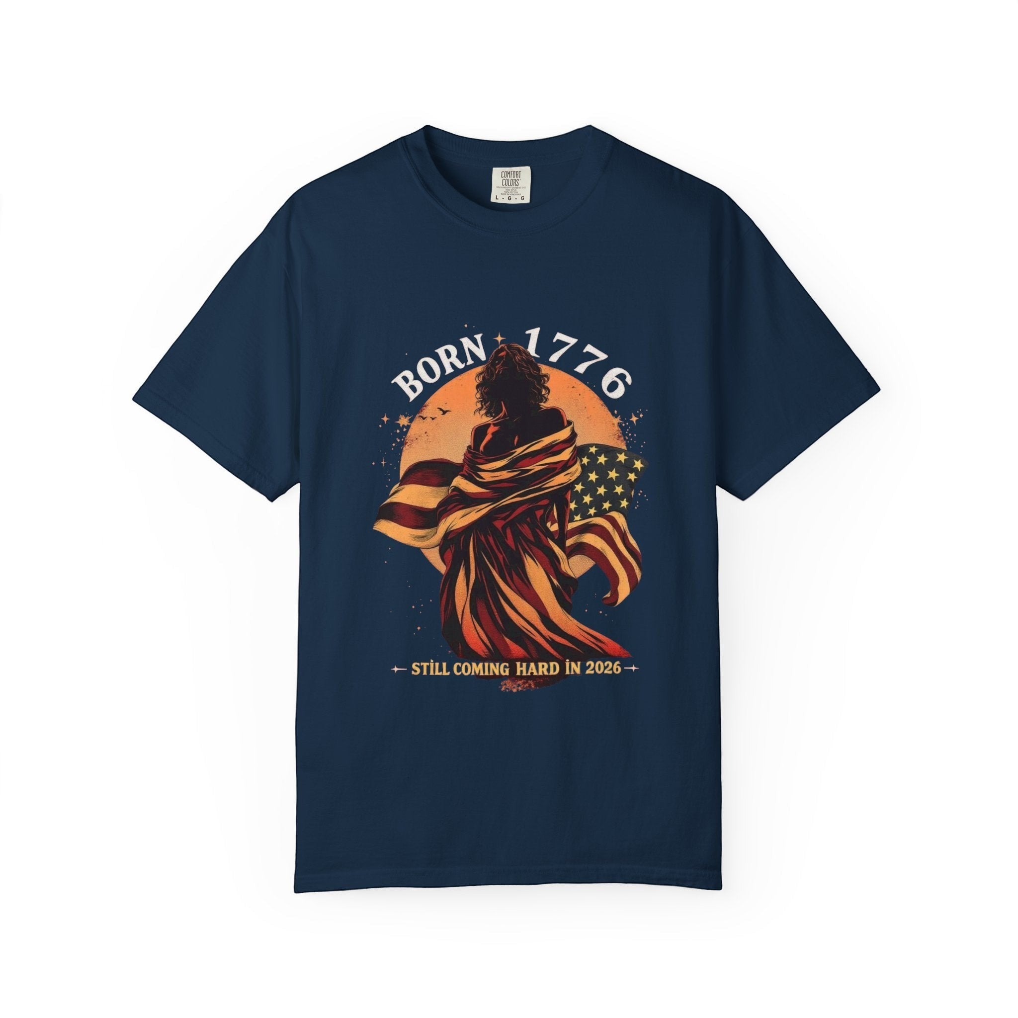 Naughty250 navy blue cotton t-shirt with a graphic of a figure wrapped in the American flag, text "Born 1776" and "Still Coming Hard in 2026".