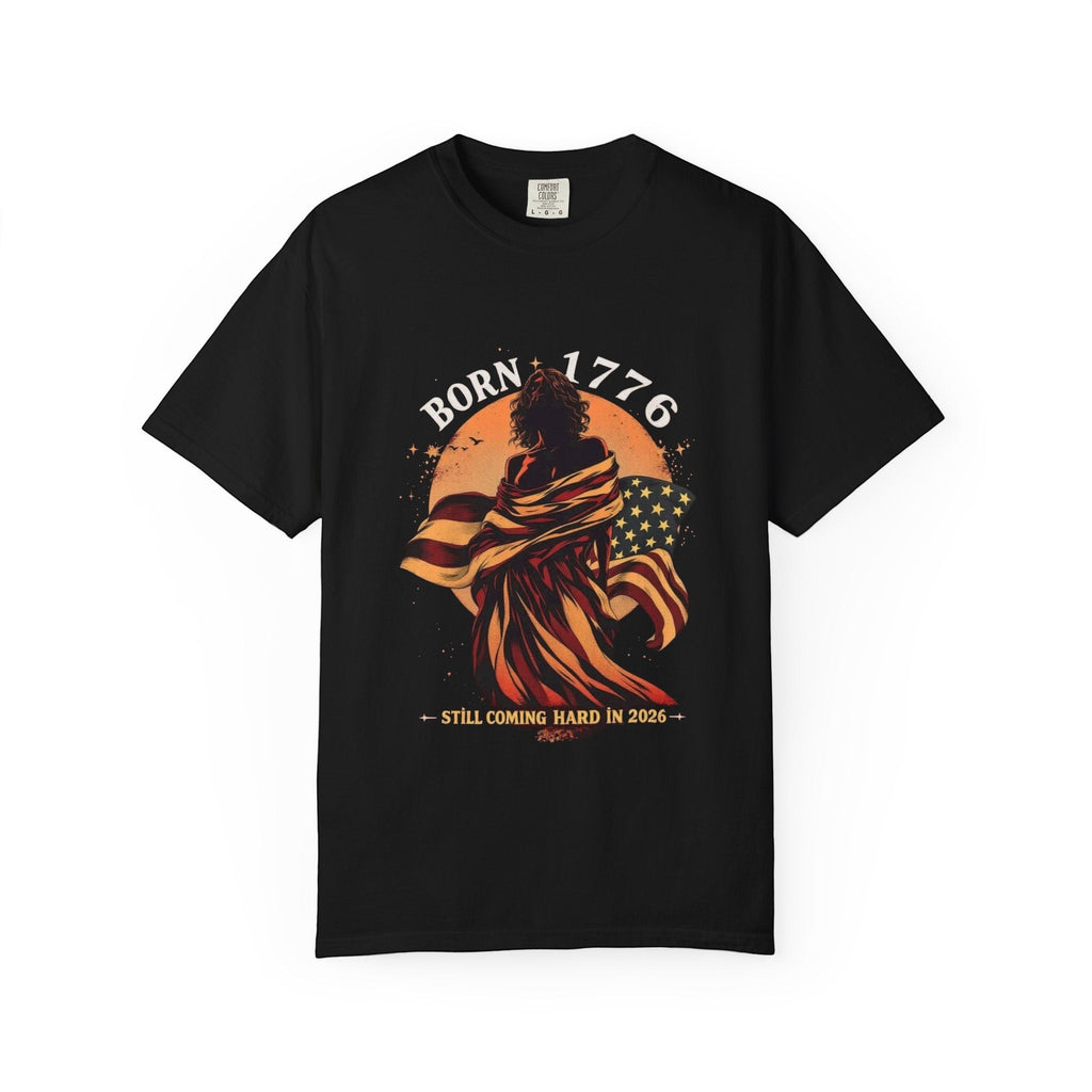 Naughty250 black cotton t-shirt with a graphic of a woman draped in the American flag, "Born 1776" text, and "Still Coming Hard in 2026" slogan.
