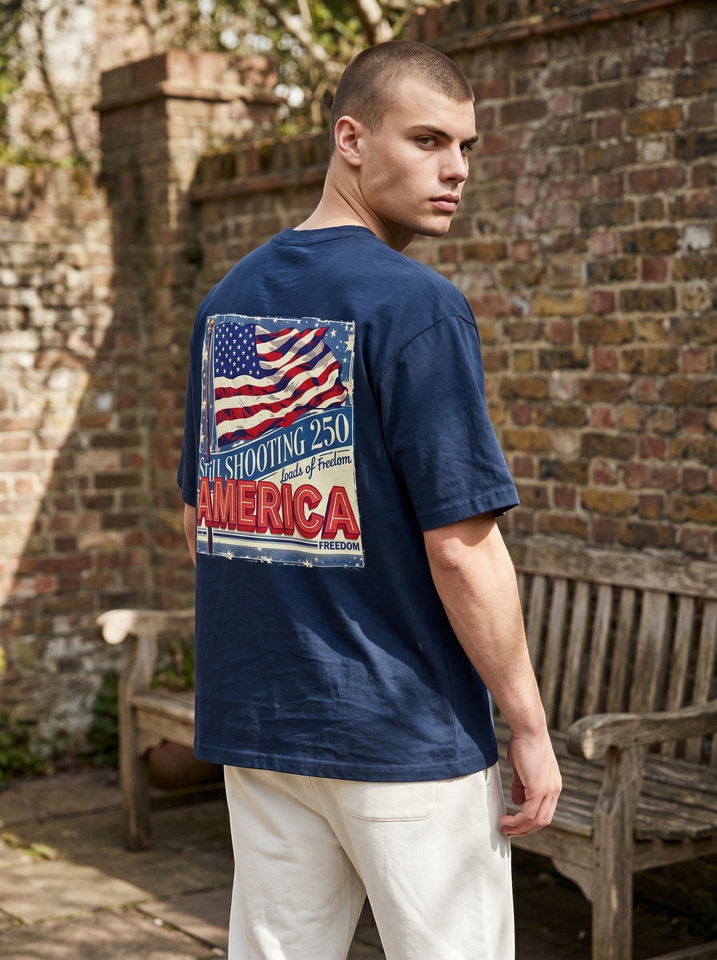 Naughty250 navy blue heavyweight cotton t-shirt with vintage American flag graphic and "Still Shooting 250 America" text.