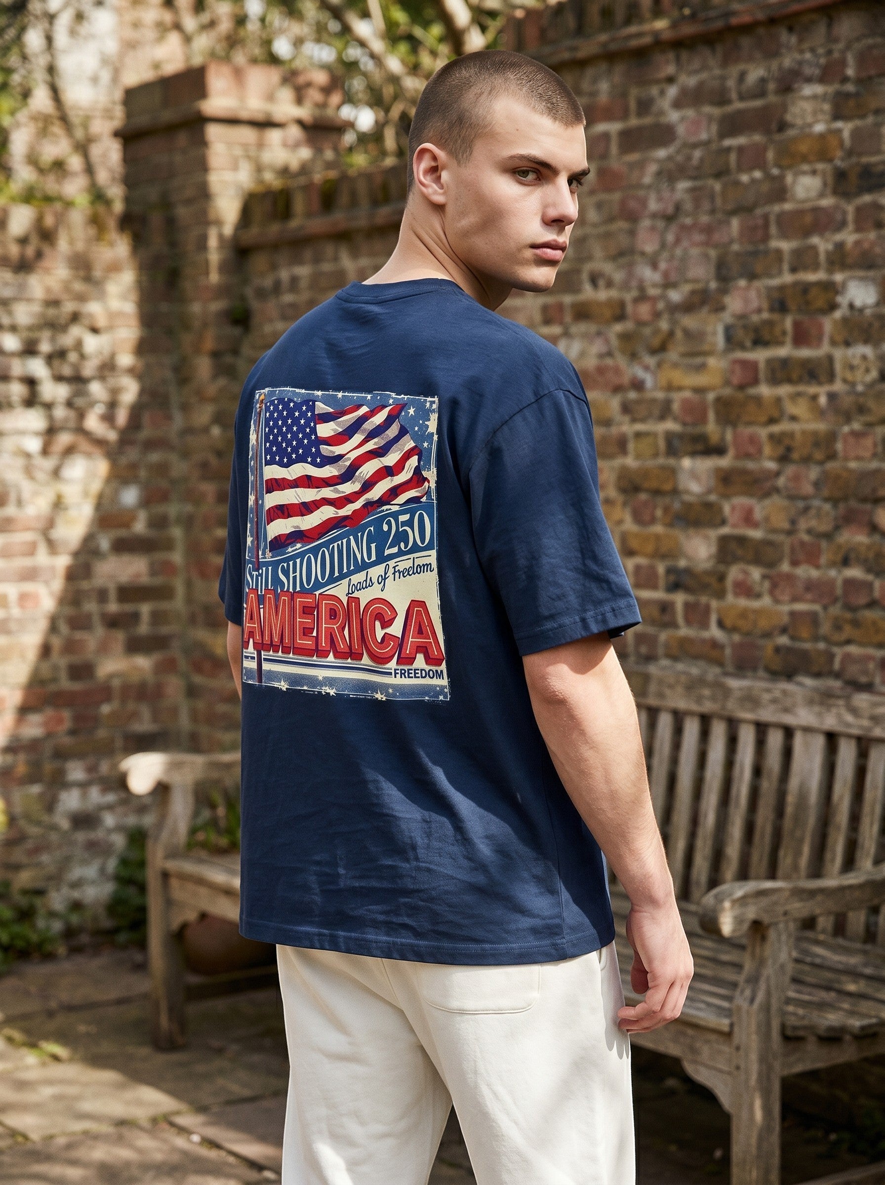 Naughty250 navy blue heavyweight cotton t-shirt with vintage American flag graphic and "Still Shooting 250 America" text.